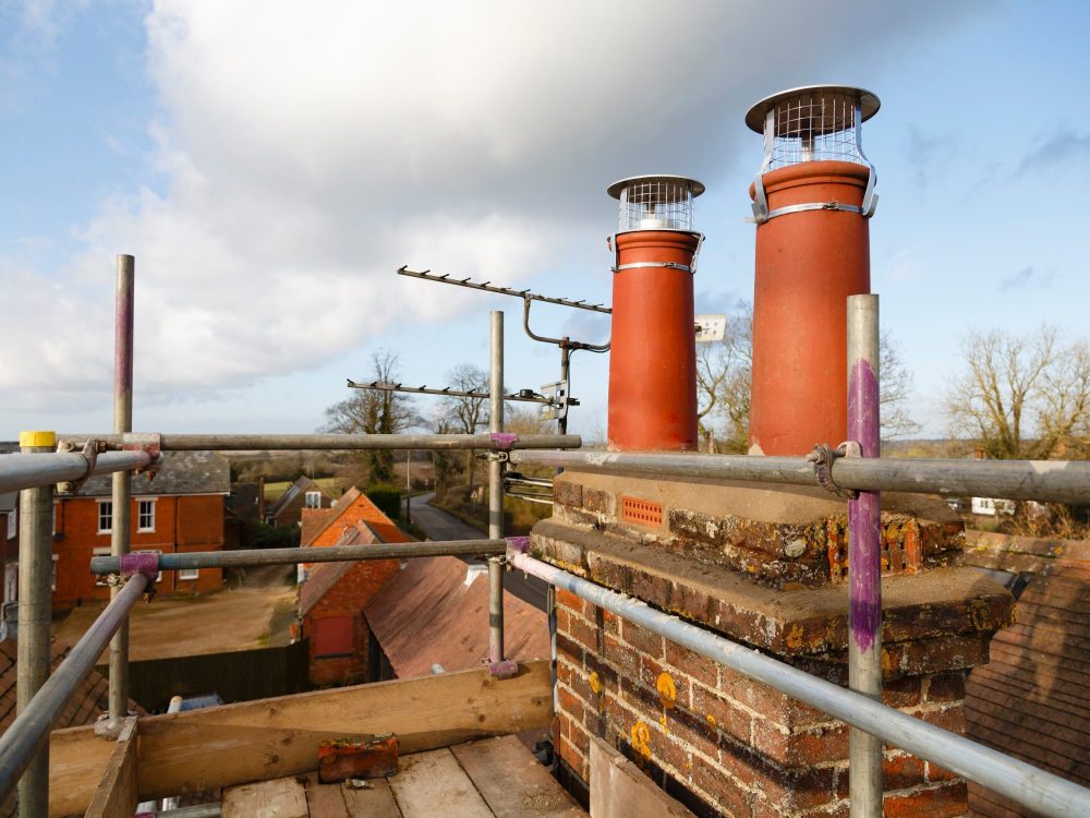 Repairing Chimney Pots With Scaffolding On A Roof. Construction trusted roof repairs